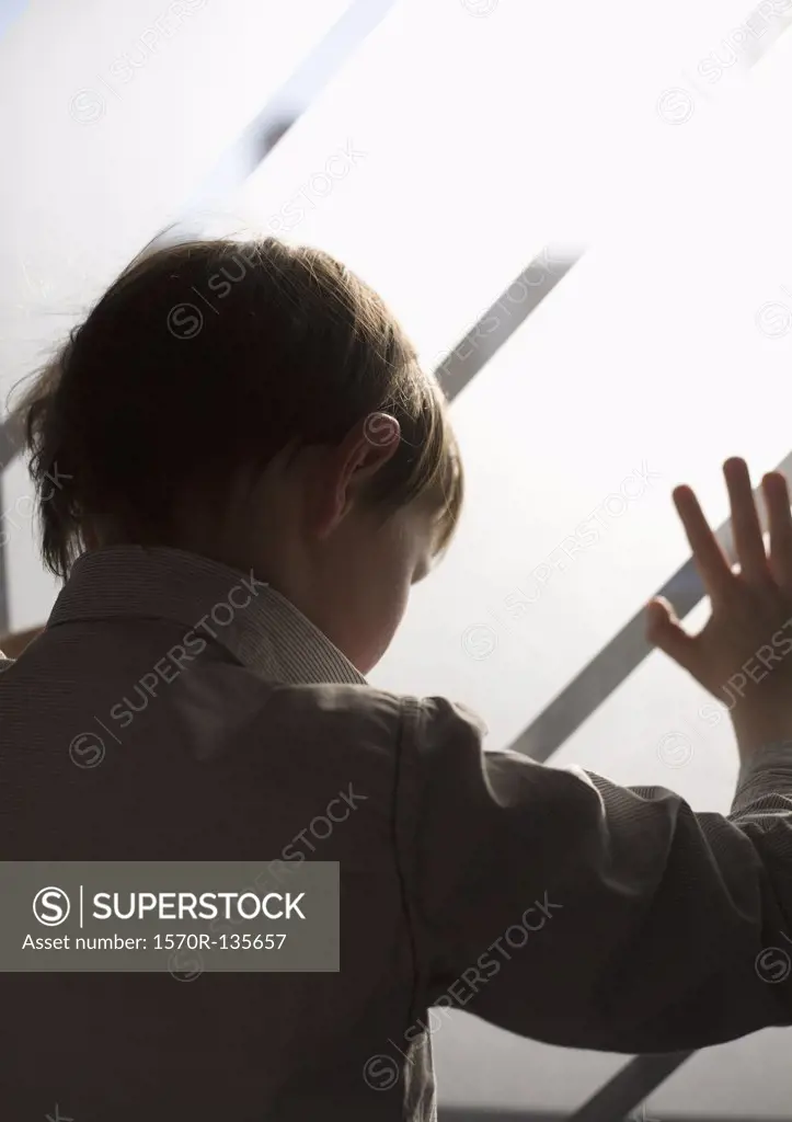 A boy looking through a frosted window