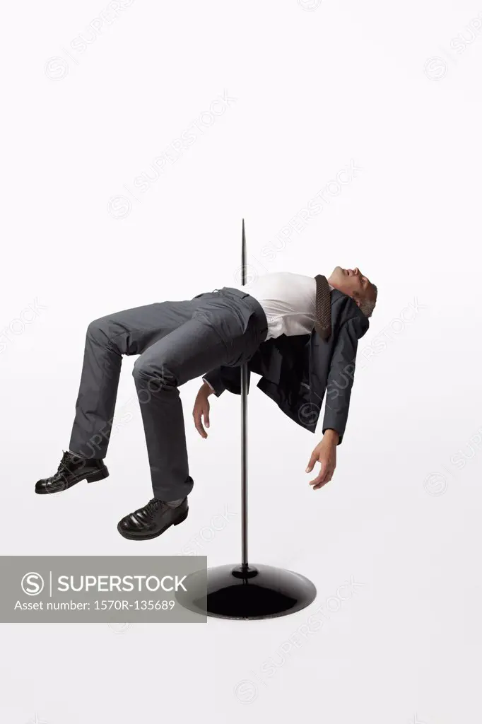 A businessman impaled on a spindle