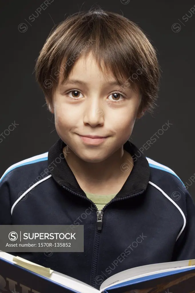 Portrait of a boy holding an open book