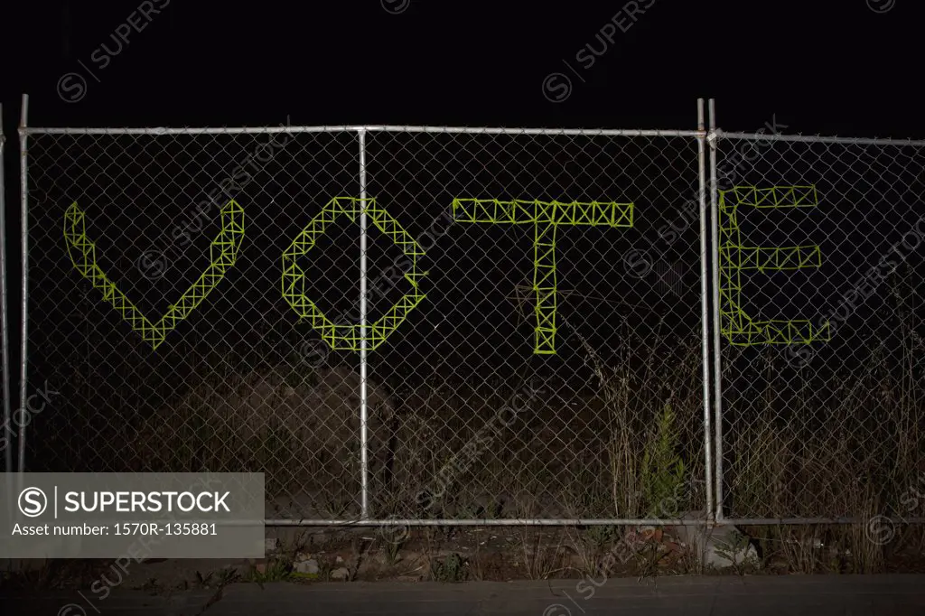 VOTE spelt on a chain link fence