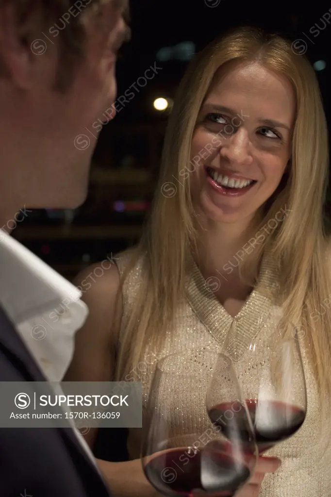 Woman smiles admiringly as a toast is made.