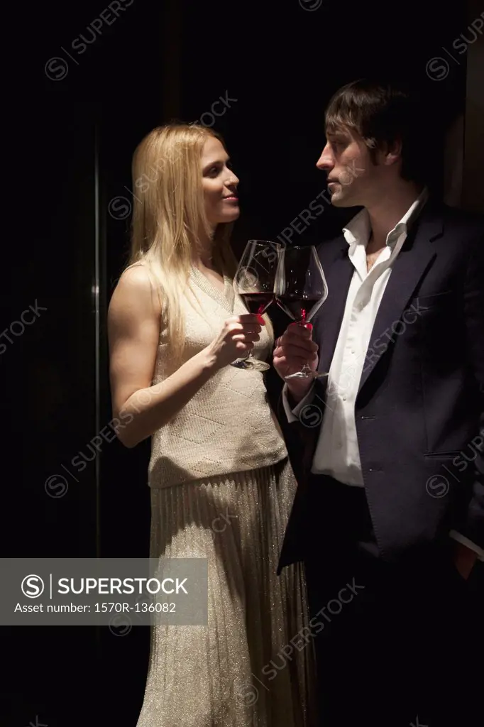 Couple make a toast with red wine.