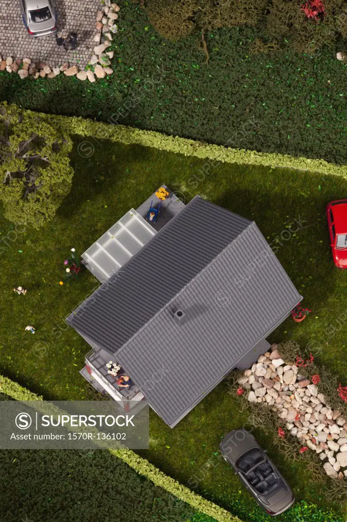 A diorama of miniature cars, people and a house, directly above
