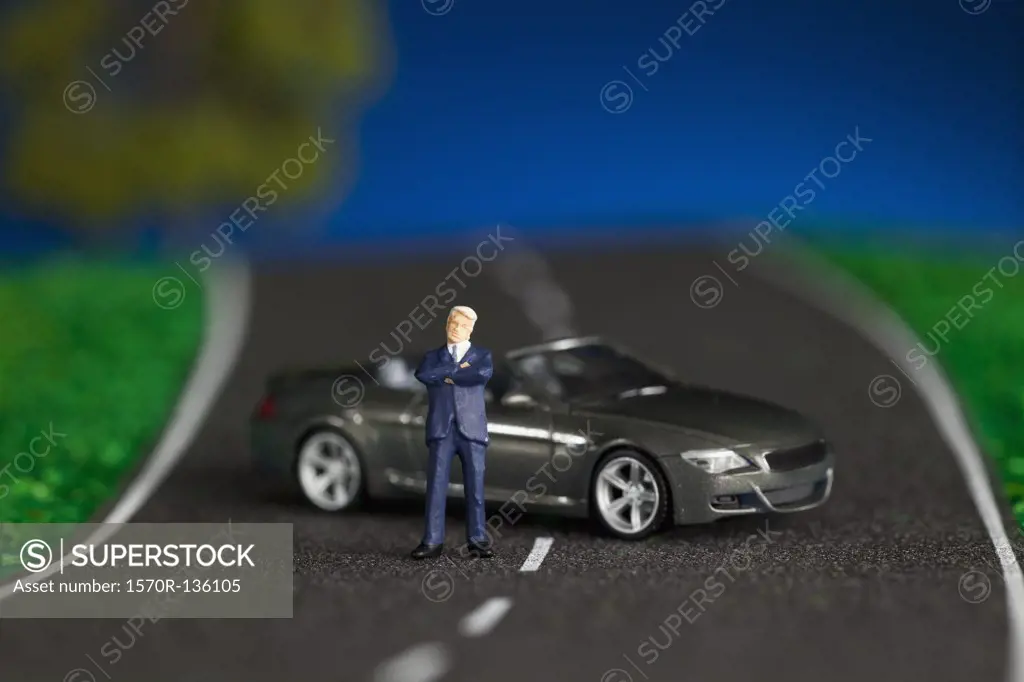 A miniature businessman figurine and miniature sports car