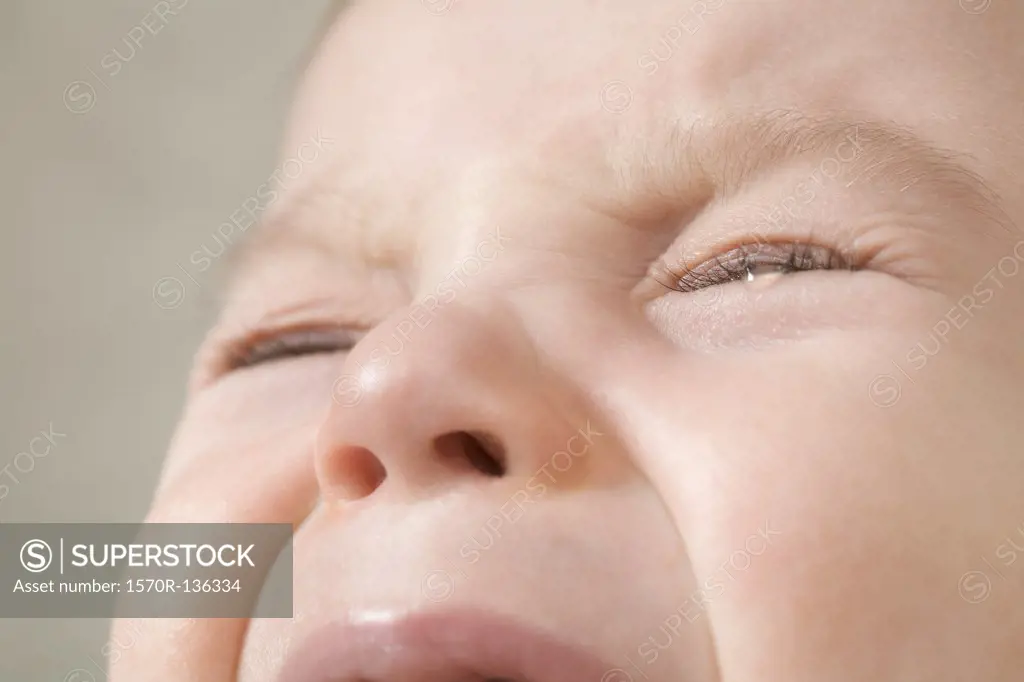 A baby boy crying, extreme close up of face