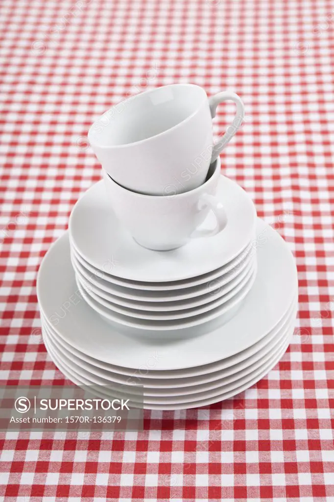 A stack of plates, saucers and coffee cups