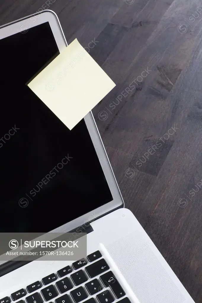A laptop with a blank adhesive note attached to it