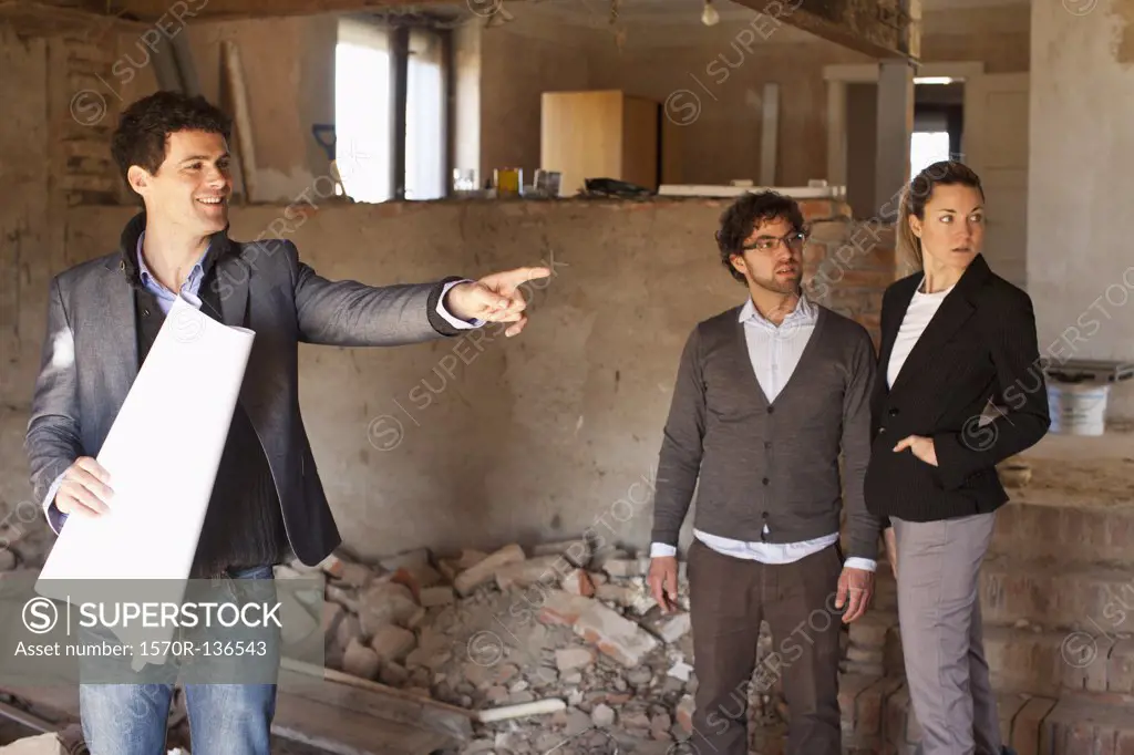 An architect showing a couple around a building site