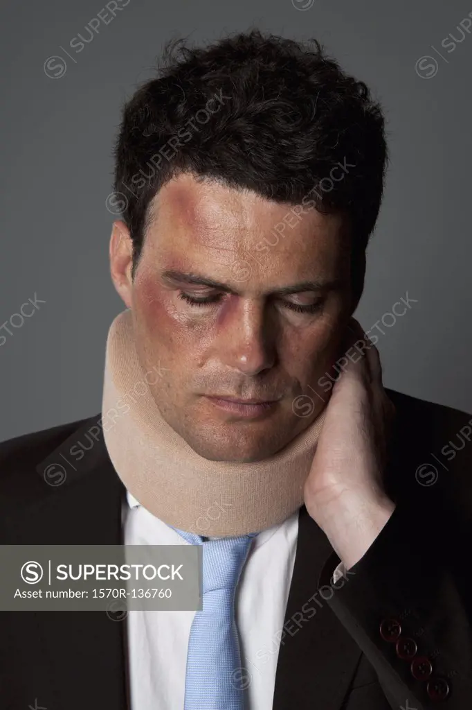 A businessman wearing a neck brace