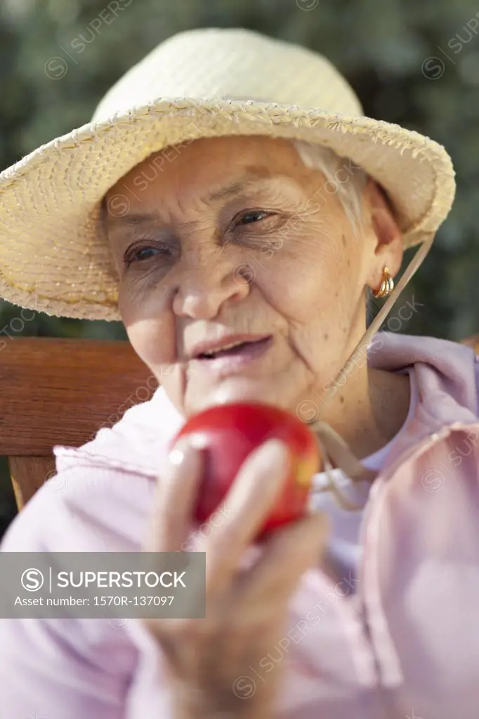 Close-up of a senior woman holding an apple