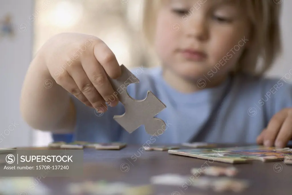A young boy holding a puzzle piece