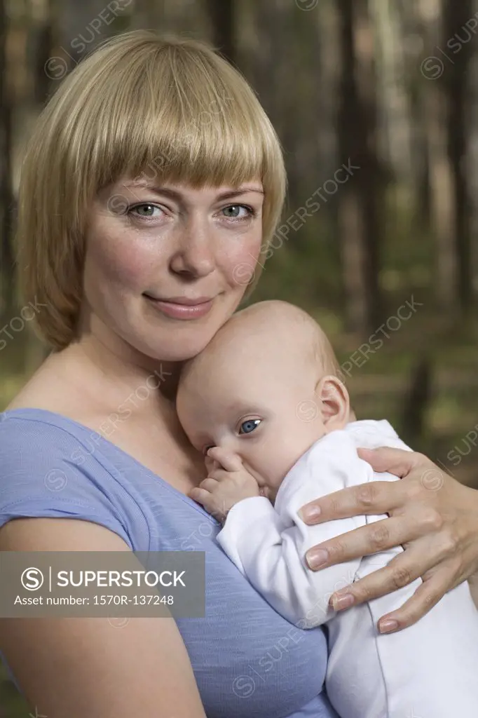 A mother holding her baby, outdoors