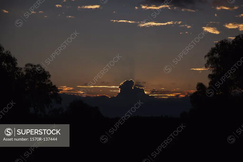 Sun setting behind clouds in a remote location