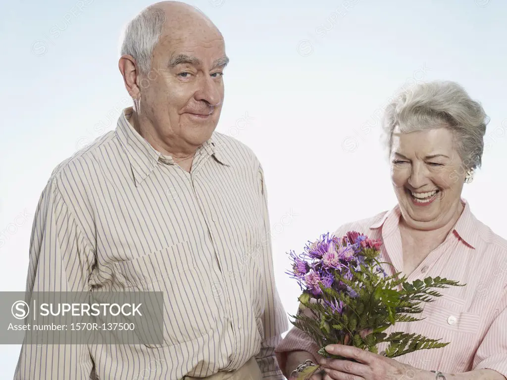 Senior man knows she's happy when he gives her flowers
