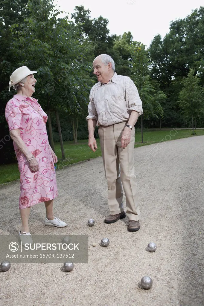 Senior man and woman play Boules in the park
