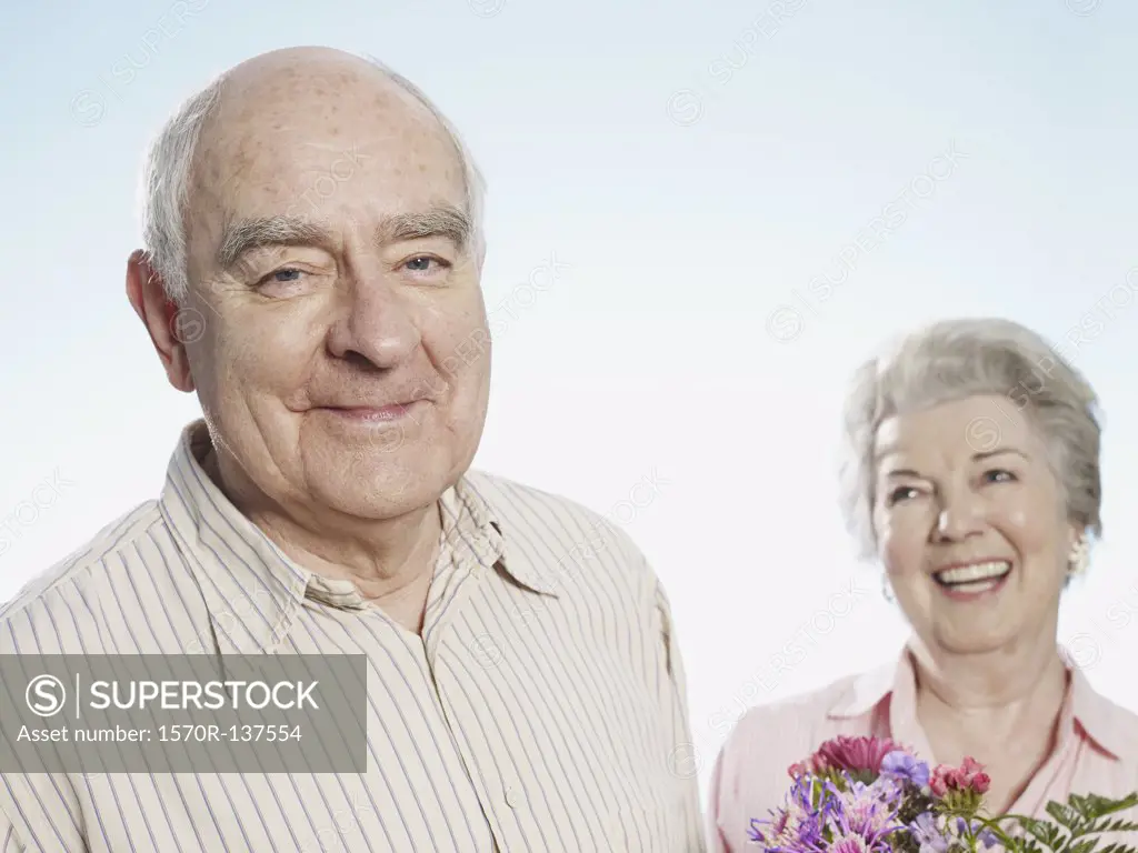 Senior man looks pleased that she likes the flowers