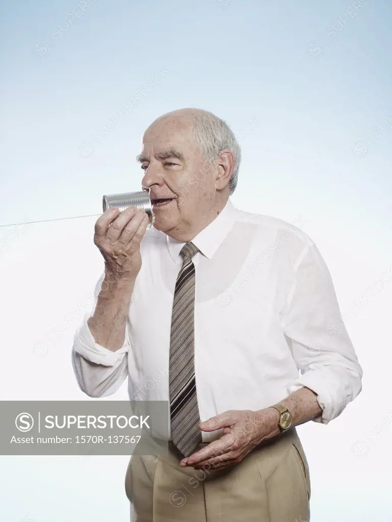 Senior man speaks into tin can phone