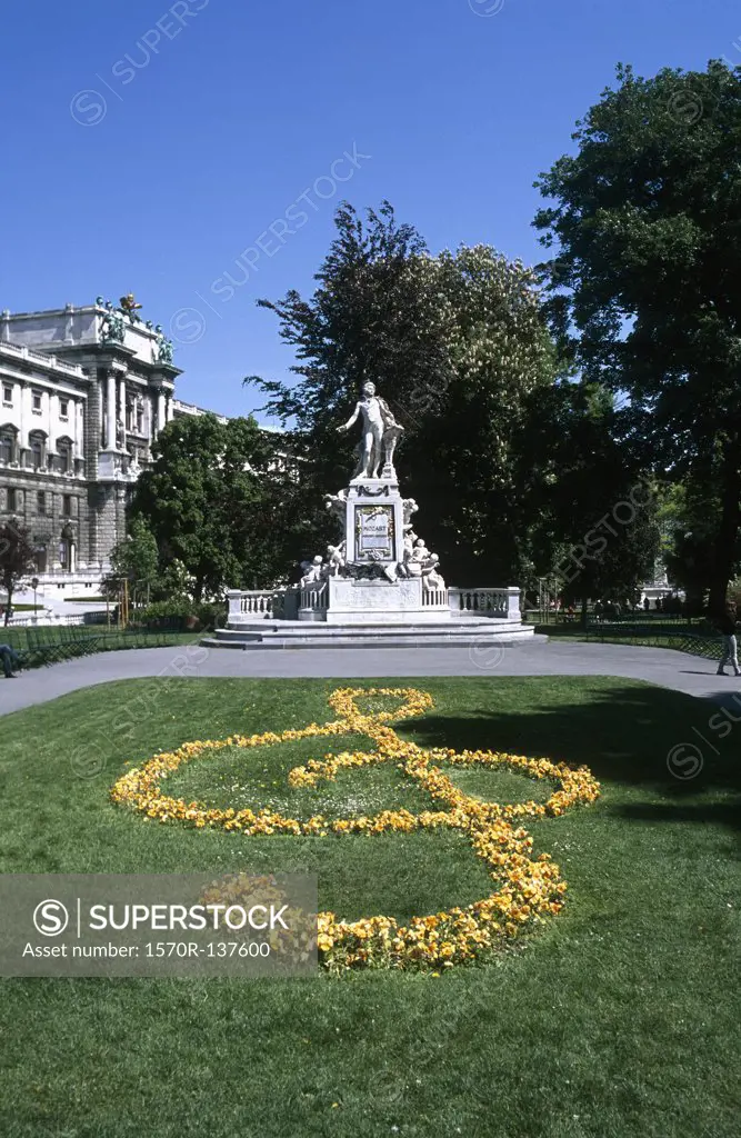 Austria, Vienna, Mozart statue in Burggarten Park and a floral treble clef in foreground