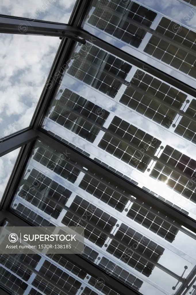Under a row of solar panels on an open roof with sky in background