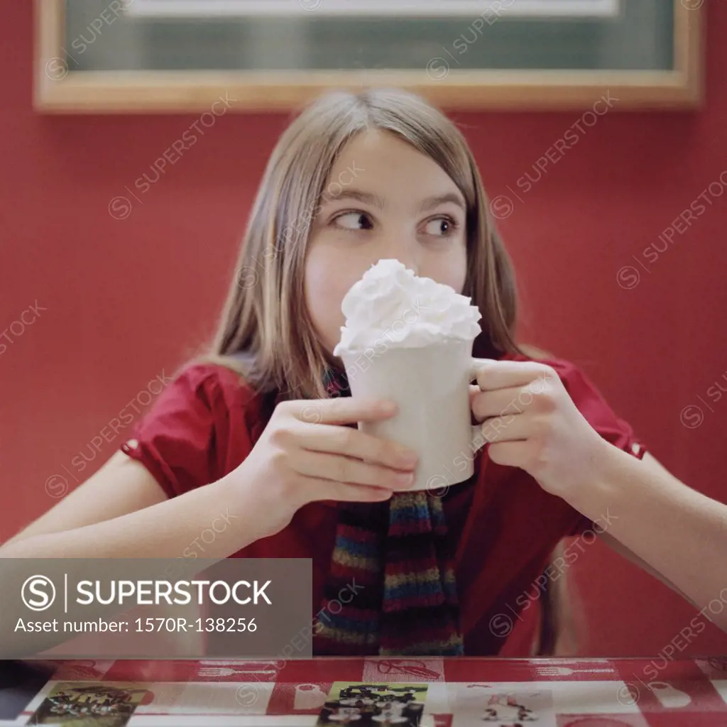 A teenage girl holding a mug of hot chocolate