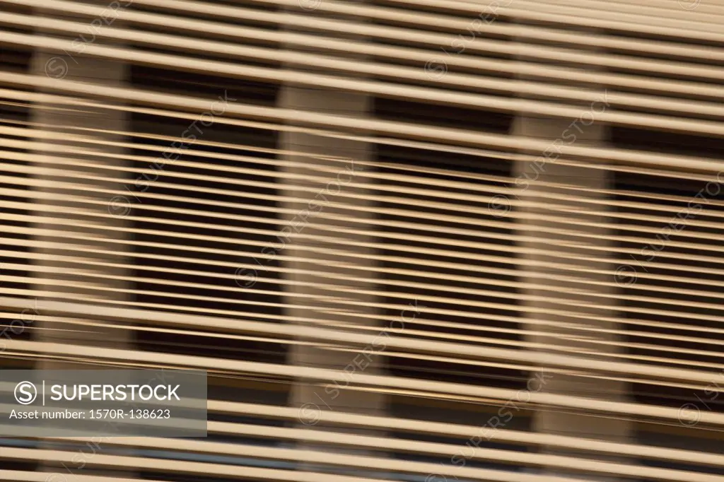 Louvered wooden slats in front of window