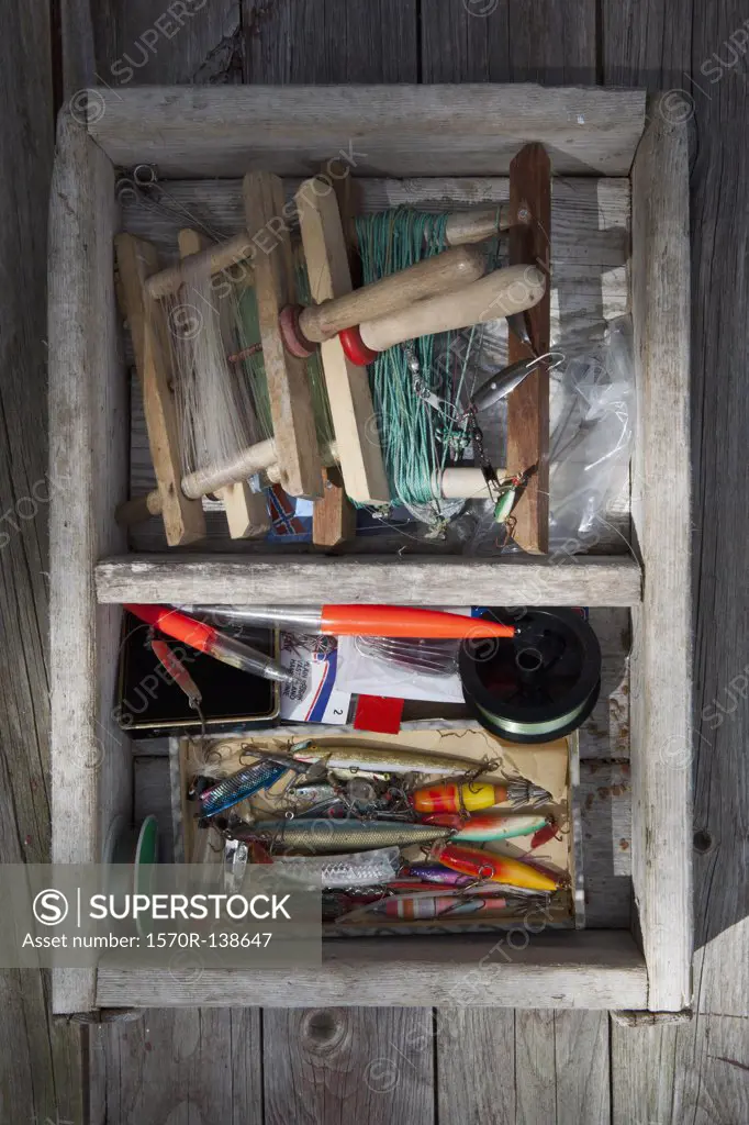Box of fishing equipment on a background of wood panels