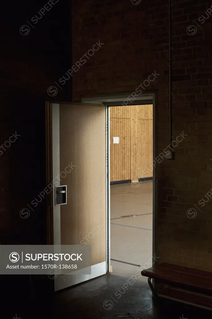Dark room with door open revealing gym