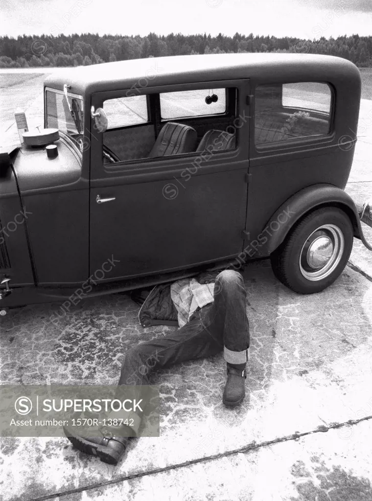 A man repairing an old car
