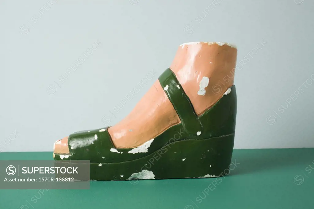A retro female mannequin's foot wearing a sandal