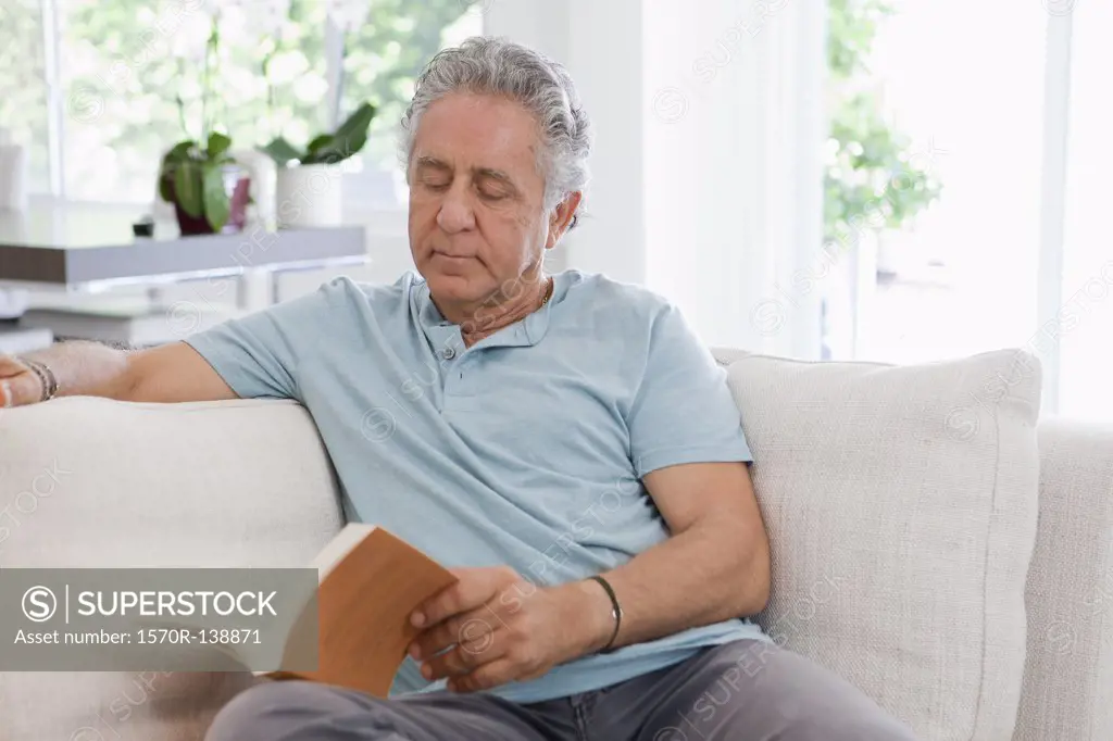 A senior man reading at home