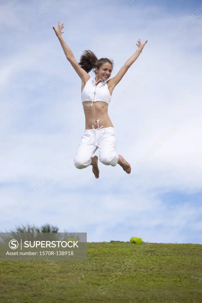 Girl jumping in mid-air in field