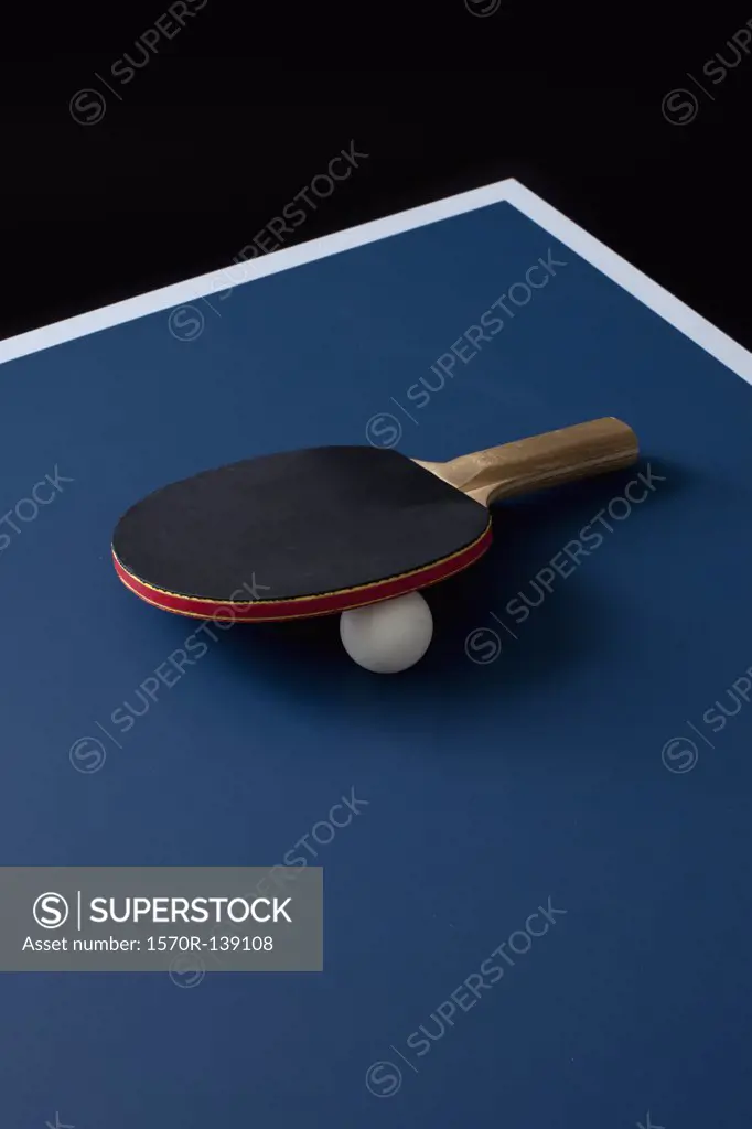 A table tennis bat and ball on a table