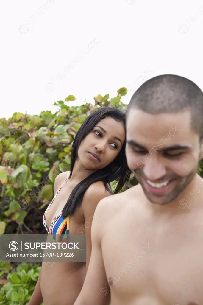 A young man teasing his girlfriend at the beach