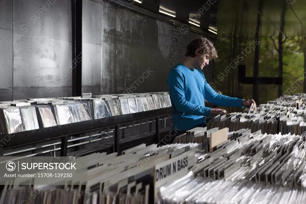 A young man searching through records in a record store
