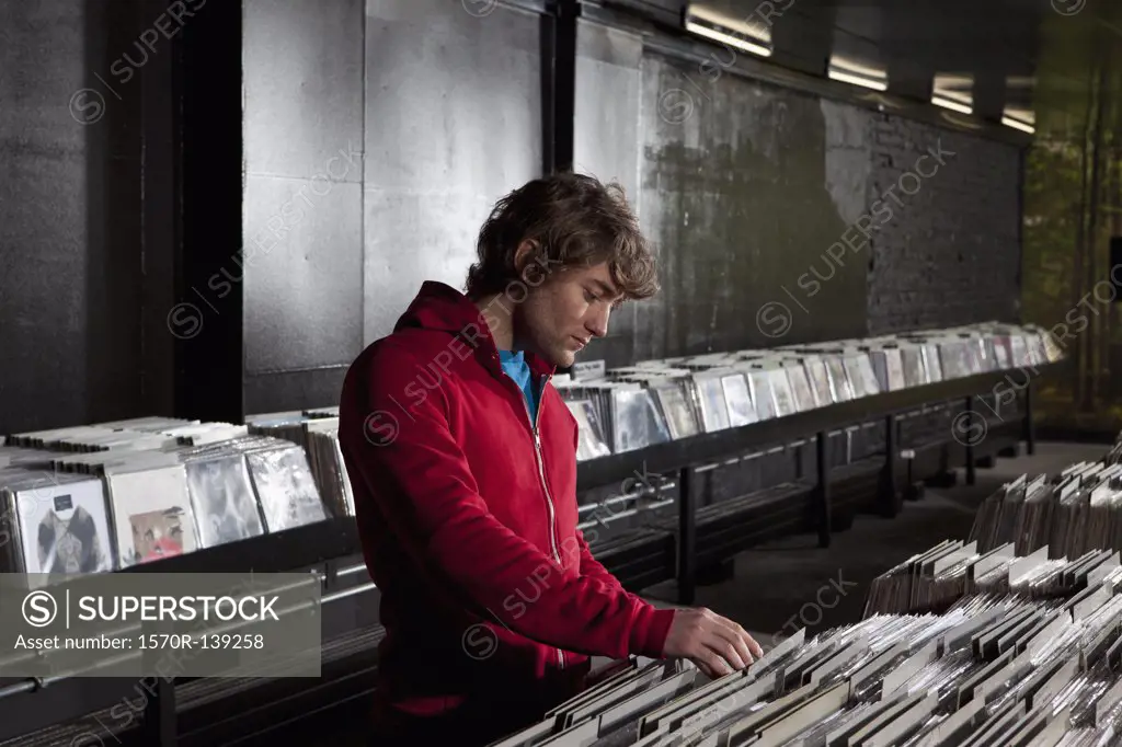 A young man looking through records at a record store