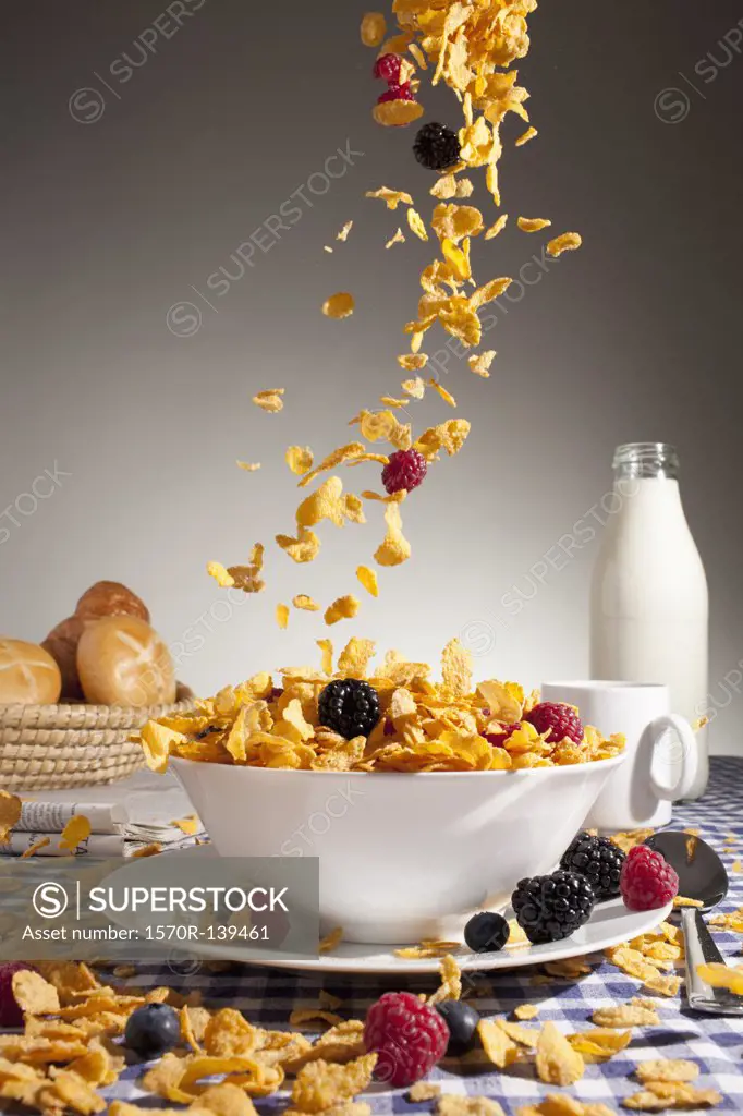 Cereal and fruit being poured into a bowl
