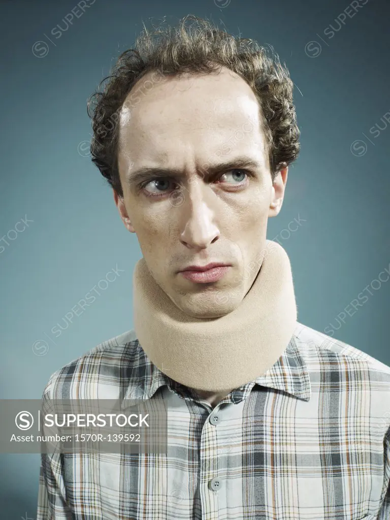 A displeased man wearing a neck brace and looking suspiciously to the side