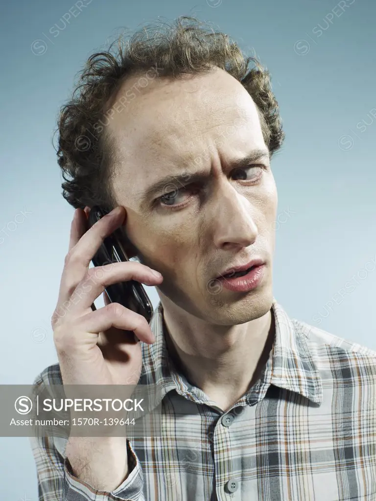 A man using a mobile phone and looking worried