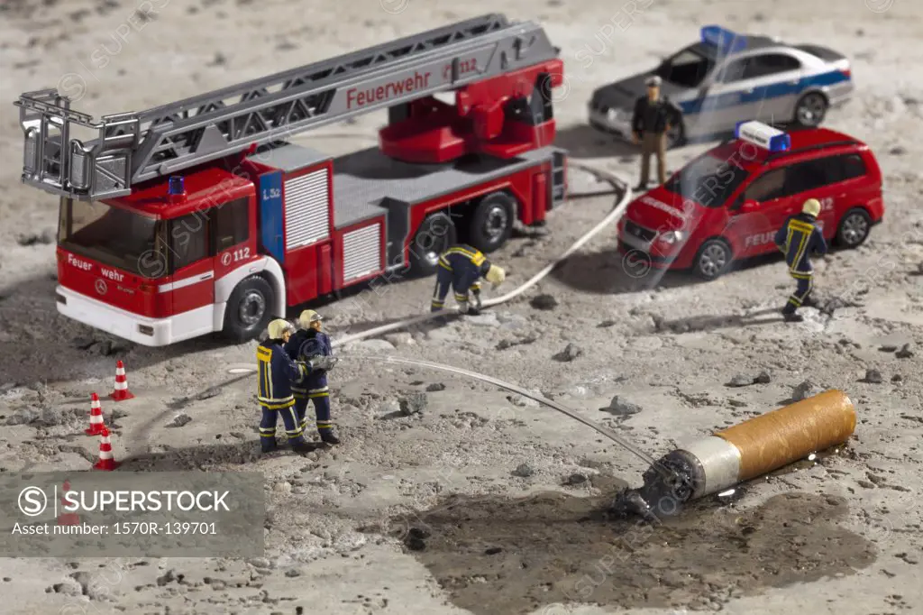 Miniature figurines of firemen using a hose to put out a smoking cigarette butt