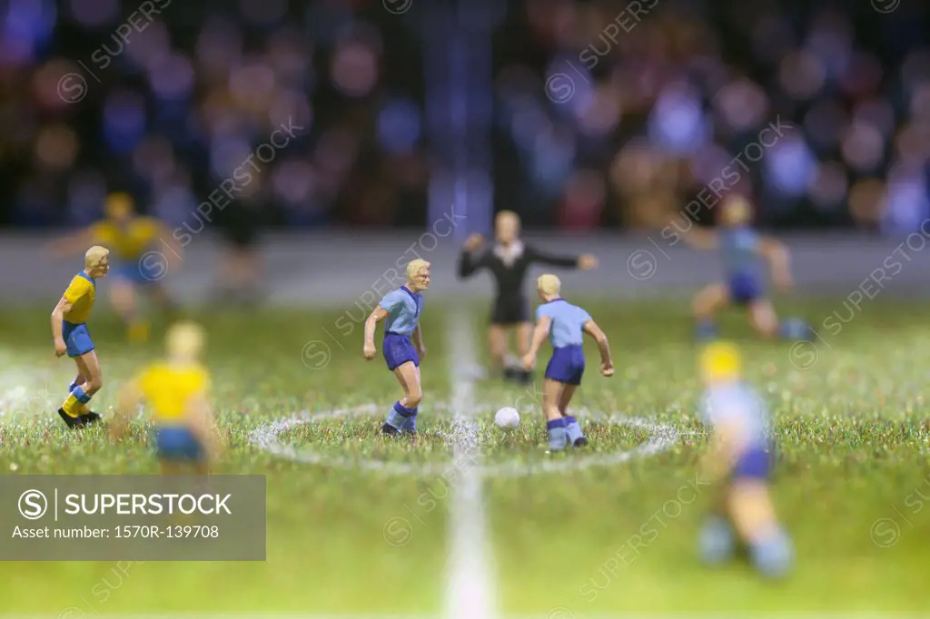 Miniature soccer player figurines at the kick-off of a soccer match