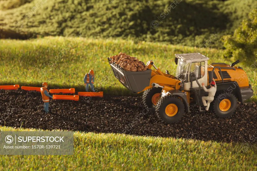 A diorama of miniature construction workers and a bulldozer