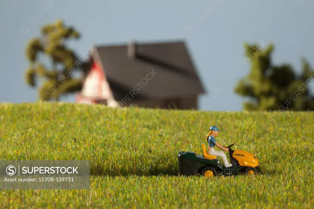 A diorama of a miniature figure using a riding lawnmower