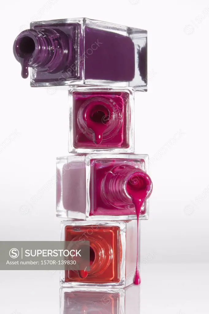 Nail polish dripping from a stack of bottles