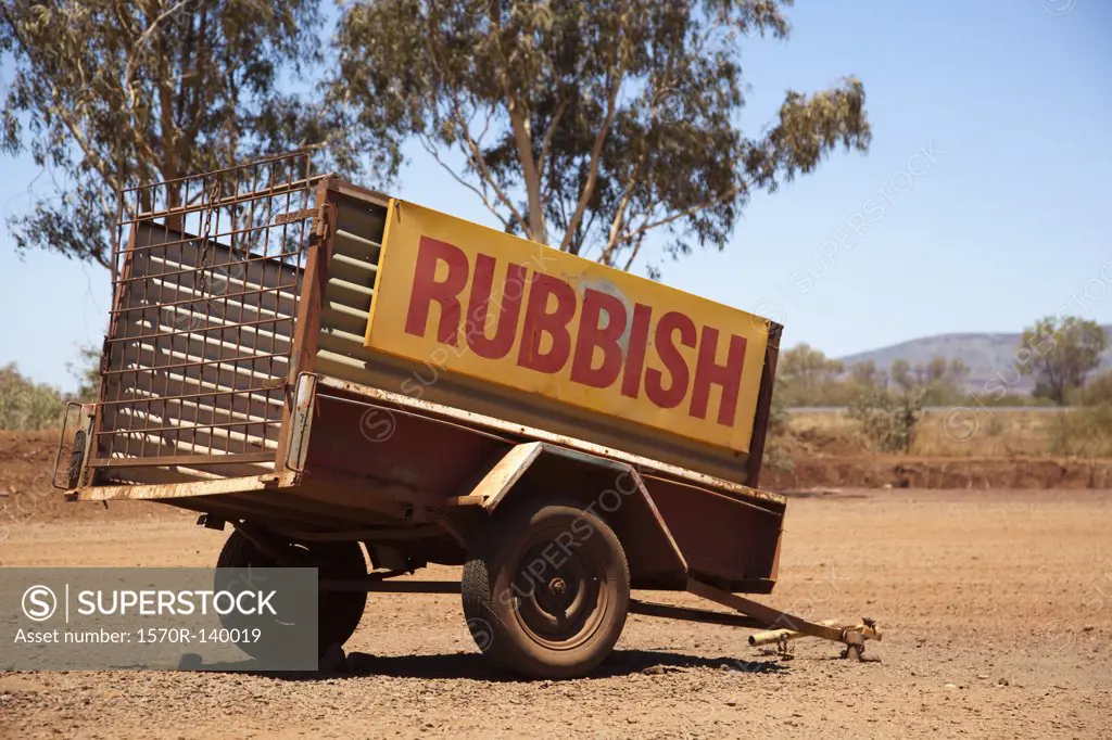 A vehicle trailer with the word Rubbish on it