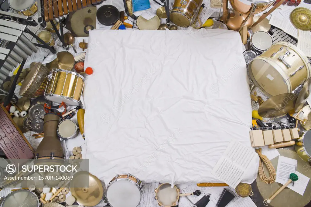 Heaps of various percussion instruments surrounding a white cloth