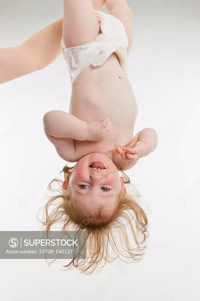 A baby girl held upside down
