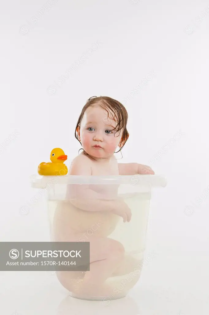 A baby girl in a bucket of water