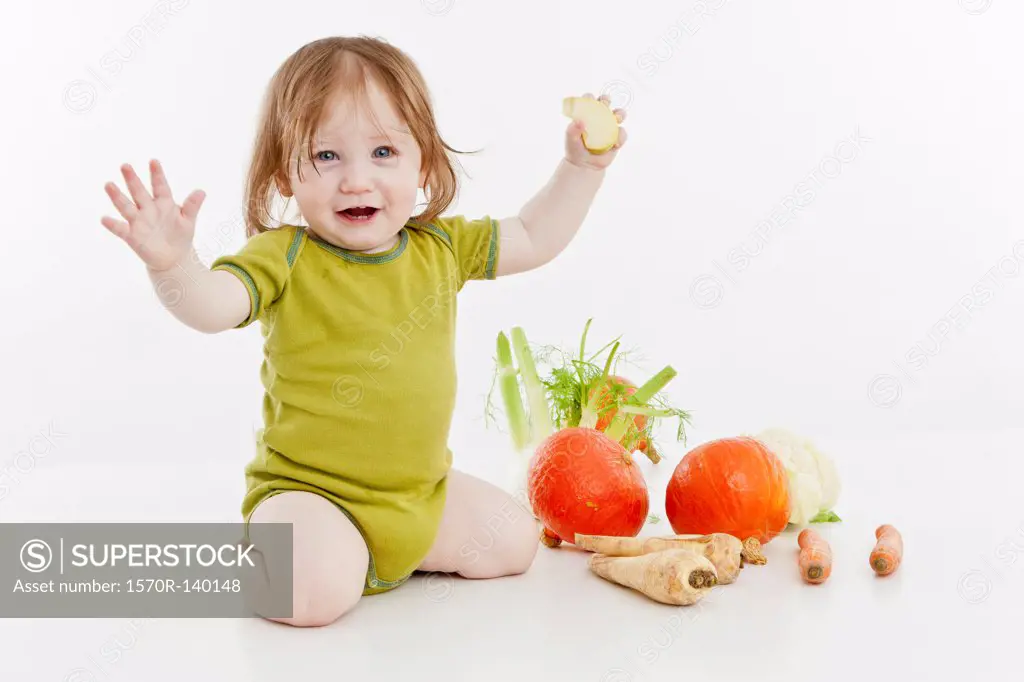A baby girl with vegetables