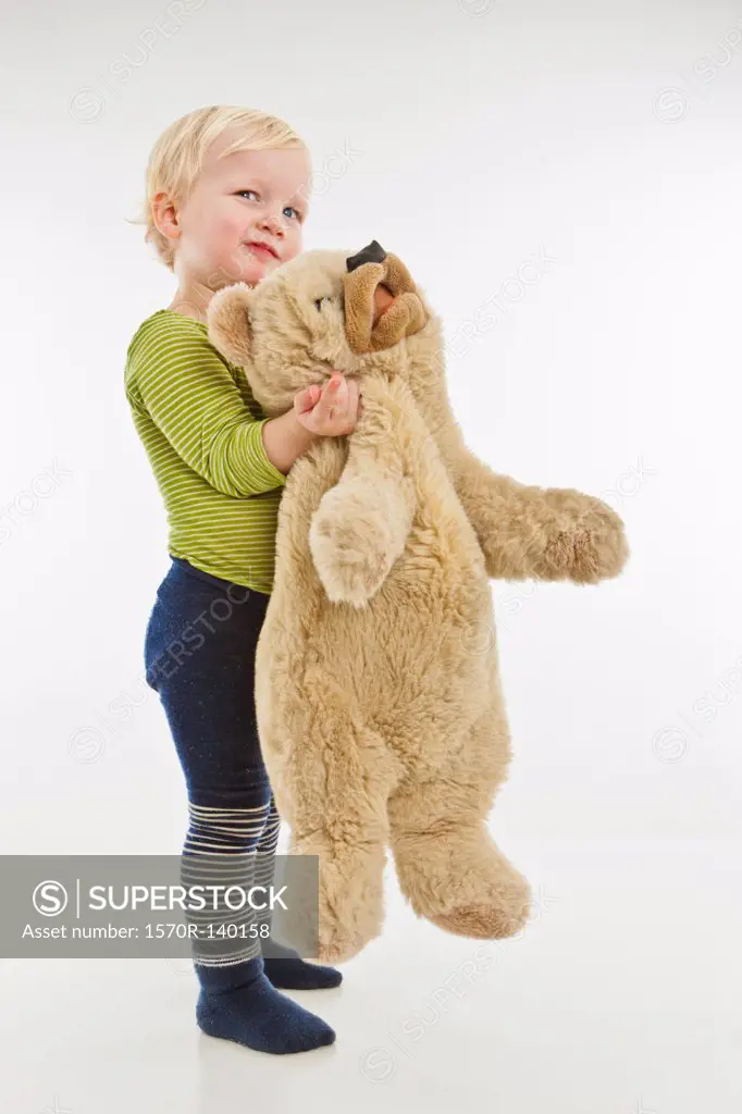 A toddler holding a teddy bear