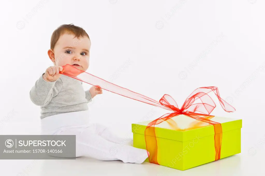 A baby girl opening a present